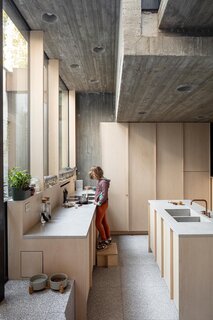 Brutalist materials like concrete and steel are balanced by the gentleness of the wooden carpentry. Ash wood is used for the cabinetry throughout, from kitchen cabinets to storage units.