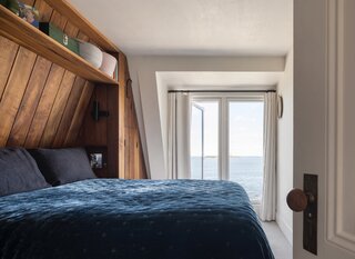 In the primary bedroom, built-in storage is ship-like and not particularly plentiful. “I’d rather live in 850-square-feet by the ocean and see the sunrise every morning than in 3,000-square-feet in the suburbs,” Caleb says.