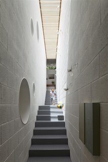 Israeli architect Pitsou Kedem’s striking family home comprises two concrete squares—one stacked on top of the other—on a sloping 7,750-square-foot plot. Inside, sections of the silicate-brick walls have circular holes cut out from them in order to connect the various rooms visually. A long, thin skylight above the stairwell floods the home with sunshine.