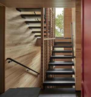 “It’s very similar to what you’d see for corn storage,” the homeowner says of the custom designed stairwell screen. On the landing, a long vertical window frames a picturesque view of the property. As a passageway that you would typically walk through quickly, the design details in the stairwell create an experience where you instead stop and linger.