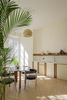 Just outside the apartment is a circular courtyard area. Lekien moved the kitchen from the rear of the apartment to the front so that it runs along the curved wall and connects to the outdoors.
