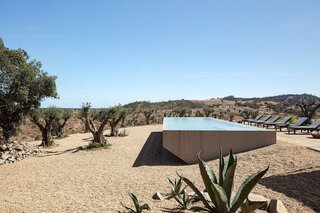 On the outskirts of Grândola—a small Alentejan town in the Setúbal district of Portugal—a dramatic architectural form sits in the vast, arid landscape amidst cork trees and herds of cows. The whitewashed guesthouse is known as Casa da Volta, which translates as "Home of the Return,