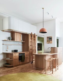 The kitchen island and cabinets at this Melbourne renovation are made of recycled timber, taking cue from the wooden bookcase that designer Kim Kneipp installed during the home’s first restyling.