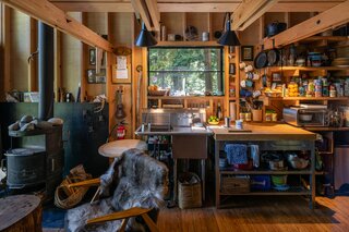 The utility sink and moveable countertop were purchased second-hand. Throughout the interiors, the framing was left exposed. Fire-resistant mineral wool insulation was applied to the exterior, then clad with Alaskan Yellow Cedar boards finished in a shou sugi ban treatment.