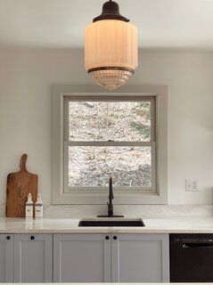 Two complementary lighting fixtures from New Hampshire Antiques co-op hang in the kitchen. "One of my good friends from college was getting married in New Hampshire, and he mentioned an antique store down the street. We probably spent three hours in there,