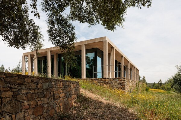 After a fire ravaged the site in rural Portugal, architect Miguel Marcelino designed this country house on its existing stone garden terraces.