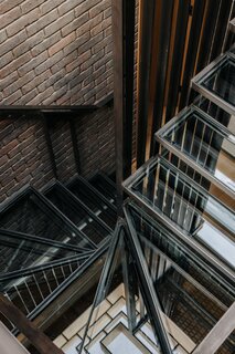 An up-close look at the sleek, winding staircase, made from black steel and glass.