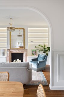 Built-in bookcases from a pink marble mantle topped by a pier mirror.