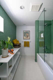 Dal Tile “Keystones” in Arctic White and Emerald cover the guest bathroom.