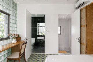 Handmade deep green ceramic tile covers the wall in the master bath.