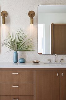 In the bathrooms, Lunt paired classic midcentury finishes (like terrazzo and wood) with fresh fixtures and lights.