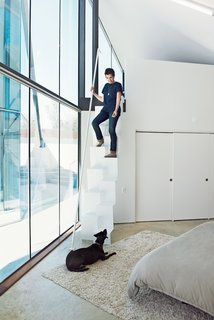 Like the pavilion holding the public spaces, the structure containing the bedrooms is clad in glass on the interior sides facing the courtyard, allowing a constant connection to the outside. Rodriguez (with dog Lupe) designed the steel stairs leading from the mezzanine-level home office to the master bedroom below. The stairs were fabricated by Austin-based Steel House MFG.