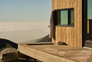 The Douglas fir deck that extends from the front facade of one of the cabins features a sunken tub that lets users feel as if they're floating above the clouds while bathing.